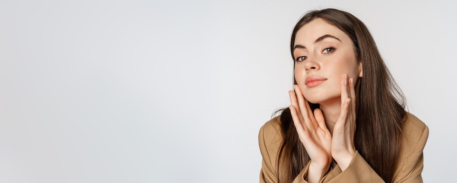 Woman with glowing skin touching her face